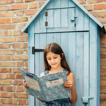 Fille lisant son carnet d'activités sur l'océan