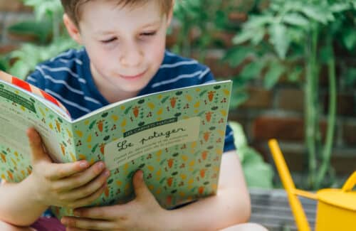 Garçon lisant le carnet sur la potager