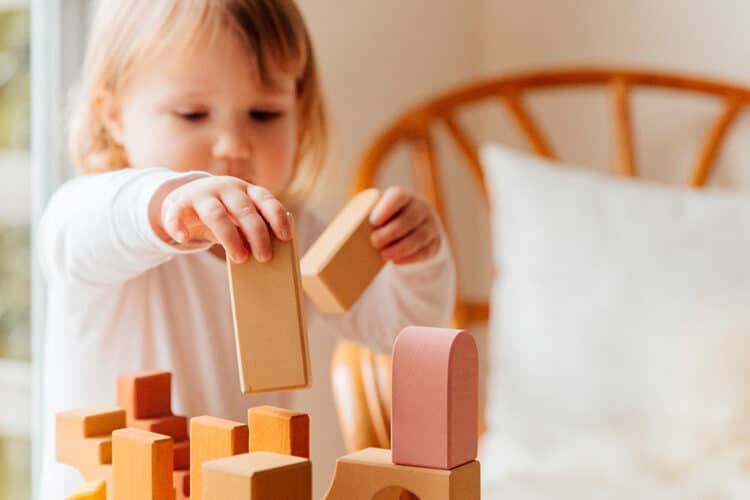 Enfant qui joue avec des cubes en bois